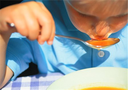 Child eating soup with spoon Stock Photo - Premium Royalty-Free, Code: 695-05776876