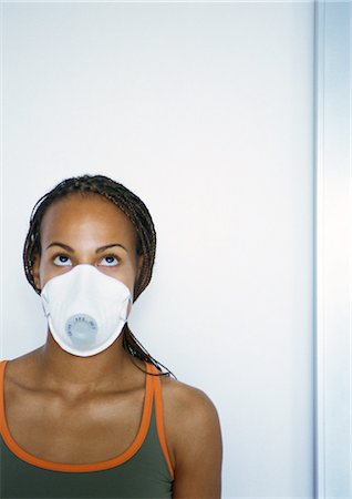 Woman wearing white dust mask over nose and mouth, portrait Stock Photo - Premium Royalty-Free, Code: 695-05776893