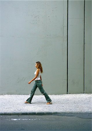 Woman walking on sidewalk, side view Foto de stock - Sin royalties Premium, Código: 695-05776905