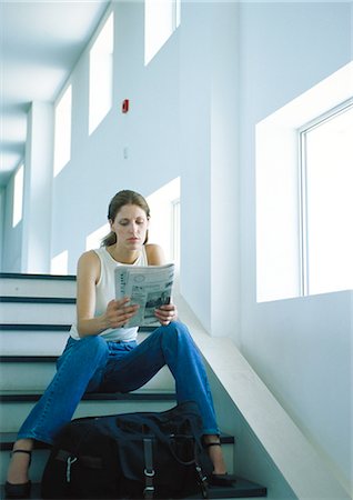 Woman sitting on stairs, reading newspaper, full length Stock Photo - Premium Royalty-Free, Code: 695-05776941