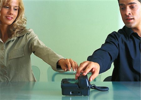 struggle to reach - Couple at table, both reaching to answer telephone at same time Stock Photo - Premium Royalty-Free, Code: 695-05776965