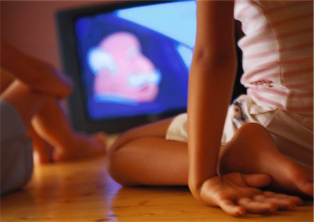 Children seated on floor watching television, close-up Stock Photo - Premium Royalty-Free, Code: 695-05776974