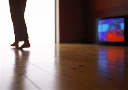 Man walking across hardwood floor past television, surface level Foto de stock - Sin royalties Premium, Código: 695-05776971