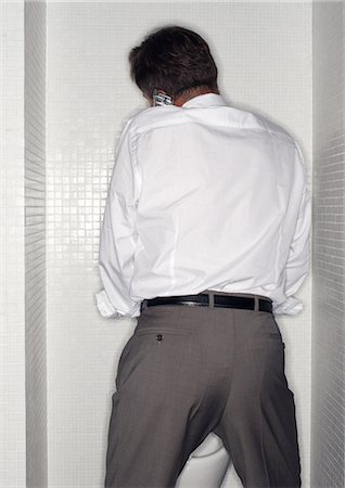 Man using cell phone in toilet Foto de stock - Sin royalties Premium, Código: 695-05776982