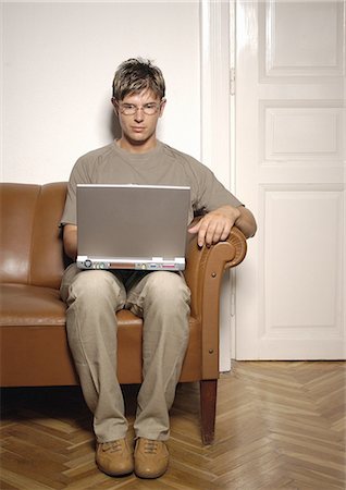 sobriety - Man sitting on sofa, using laptop computer Stock Photo - Premium Royalty-Free, Code: 695-05777021