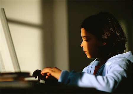Young girl sitting, typing on laptop Foto de stock - Royalty Free Premium, Número: 695-05777065