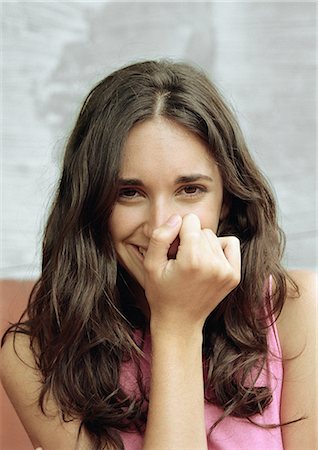 Woman covering mouth with fist, smiling, portrait Foto de stock - Royalty Free Premium, Número: 695-05777134