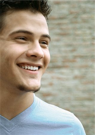 Teenage boy smiling looking away, close up portrait Stock Photo - Premium Royalty-Free, Code: 695-05777139