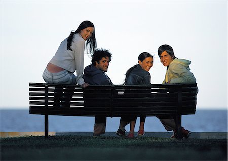 sunset hang out - Friends sitting on bench at sunset, smiling at camera Foto de stock - Sin royalties Premium, Código: 695-05777180