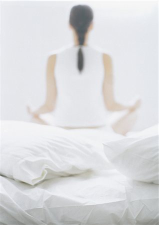 Woman sitting in lotus position on bed, rear view, blurred Foto de stock - Royalty Free Premium, Número: 695-05777182