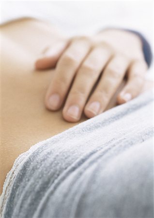 Woman's hand on bare stomach, close-up Foto de stock - Royalty Free Premium, Número: 695-05777191