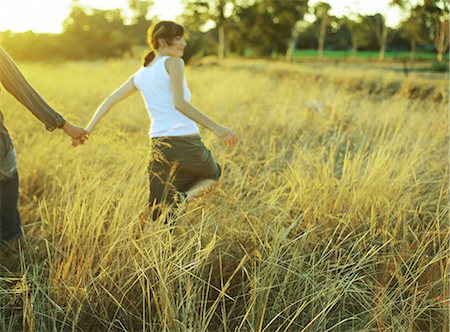 Couple walking in field of tall grass Foto de stock - Royalty Free Premium, Número: 695-05777230