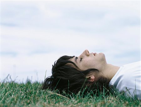 simsearch:632-01149081,k - Young man lying on back in grass with eyes closed, head and shoulders Stock Photo - Premium Royalty-Free, Code: 695-05777306