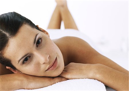 simsearch:632-01151438,k - Woman looking at camera, lying on massage table with legs up, focus on face in foreground Foto de stock - Sin royalties Premium, Código: 695-05777363