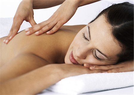 Woman massaging woman lying on stomach with eyes closed Foto de stock - Sin royalties Premium, Código: 695-05777383