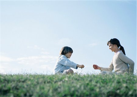 simsearch:632-01156987,k - Boy and girl sitting on grass playing rock paper scissors Stock Photo - Premium Royalty-Free, Code: 695-05777419