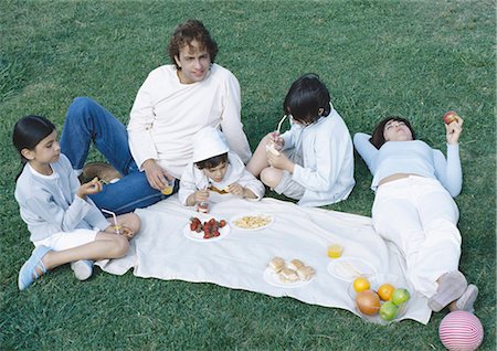 family meal overhead - Parents with boys and girl having picnic on lawn Stock Photo - Premium Royalty-Free, Code: 695-05777436