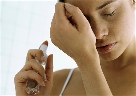 perfume bottle on white - Young woman holding perfume bottle, smelling wrist, close-up Stock Photo - Premium Royalty-Free, Code: 695-05777480