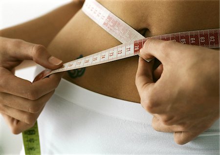 simsearch:695-05773352,k - Woman measuring waist, close-up Foto de stock - Sin royalties Premium, Código: 695-05777483