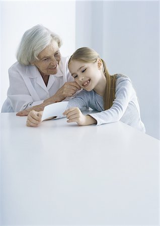 family stroke sit - Grandmother and granddaughter looking at photo together Stock Photo - Premium Royalty-Free, Code: 695-05777499