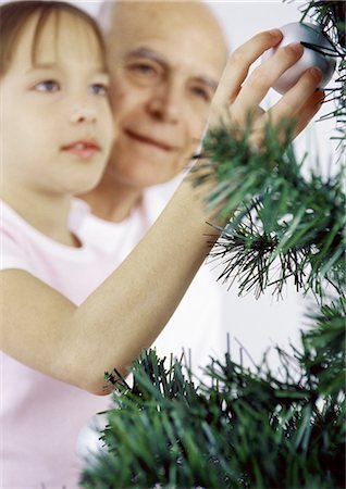 Girl and grandfather decorating Christmas tree Stock Photo - Premium Royalty-Free, Code: 695-05777528