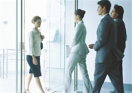 executive office profile - Businesspeople entering and exiting through glass doors Stock Photo - Premium Royalty-Free, Code: 695-05777541
