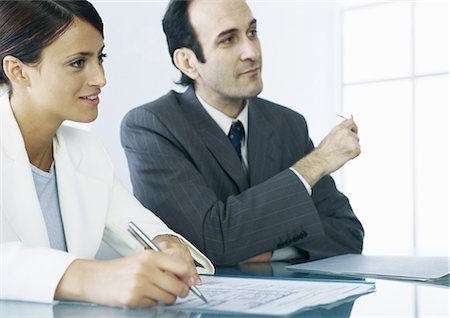 Businessman and businesswoman sitting at table with documents Stock Photo - Premium Royalty-Free, Code: 695-05777599