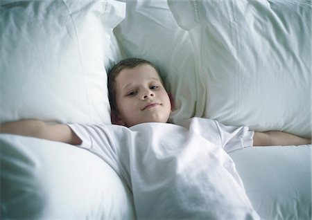 snow angel - Boy lying on bed with arms out Stock Photo - Premium Royalty-Free, Code: 695-05777698