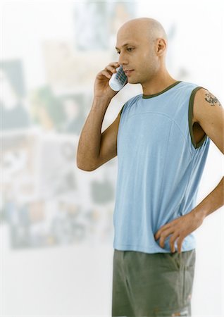 Man with shaved head standing and talking on phone Stock Photo - Premium Royalty-Free, Code: 695-05777789