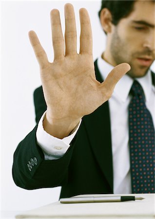 penna stilografica - Businessman holding up hand and looking down Fotografie stock - Premium Royalty-Free, Codice: 695-05777806