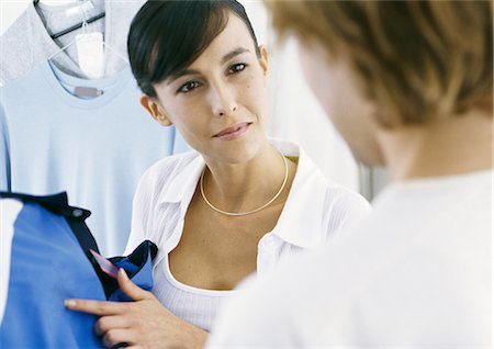 Woman pointing to shirt, looking at man Stock Photo - Premium Royalty-Free, Code: 695-05777801