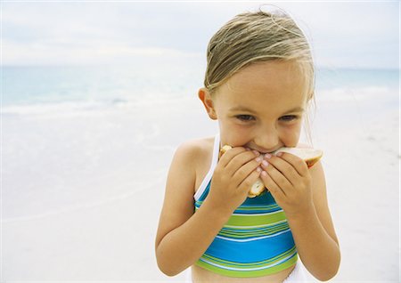 Girl eating sandwich on beach Foto de stock - Sin royalties Premium, Código: 695-05777925