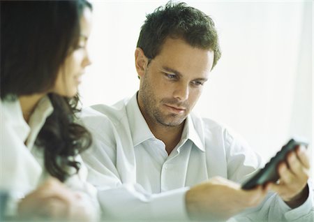 financial reward - Young couple considering figure displayed on calculator Foto de stock - Sin royalties Premium, Código: 695-05778254