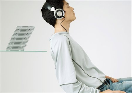 Young man wearing headphone listening to music Stock Photo - Premium Royalty-Free, Code: 695-05778445