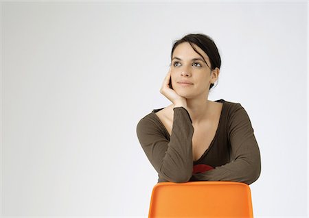 Young woman sitting backwards on chair, portrait Foto de stock - Sin royalties Premium, Código: 695-05778469