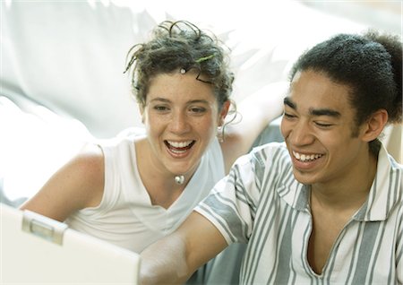 dreads teen - Young couple looking at laptop, smiling Stock Photo - Premium Royalty-Free, Code: 695-05778539