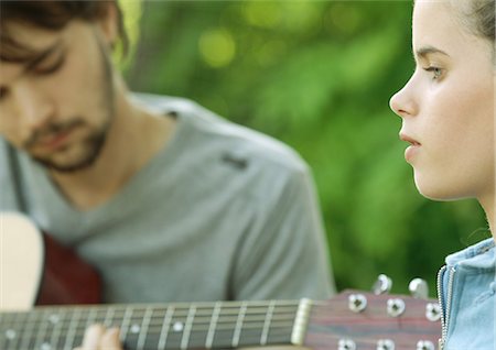 Young woman listening to young man playing guitar Stock Photo - Premium Royalty-Free, Code: 695-05778553