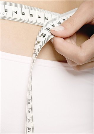 pesandose - Woman measuring waist, extreme close-up Foto de stock - Sin royalties Premium, Código: 695-05778678