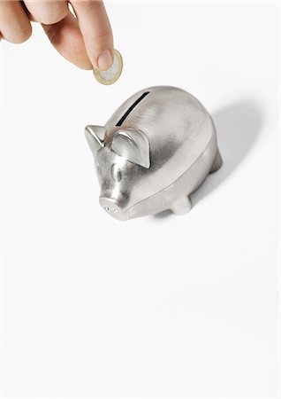 people depositing in the bank - Hand inserting coin into piggy bank Stock Photo - Premium Royalty-Free, Code: 695-05778684