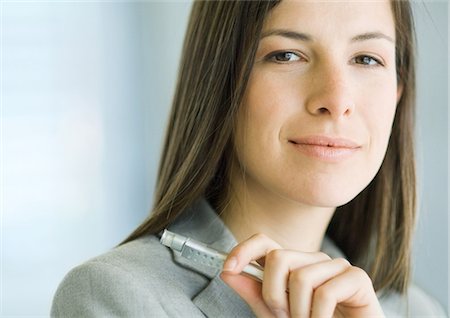 female executive power suit - Businesswoman holding pen, close-up, portrait Stock Photo - Premium Royalty-Free, Code: 695-05778825