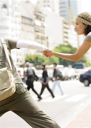 Young couple holding hands, running across street Stock Photo - Premium Royalty-Free, Code: 695-05778867