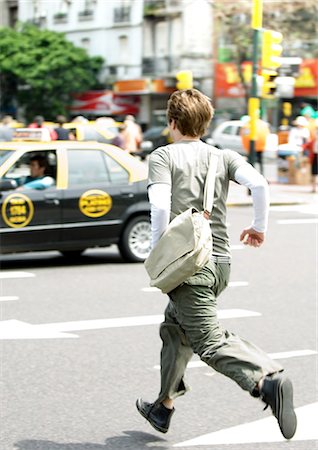 Young man running across street Stock Photo - Premium Royalty-Free, Code: 695-05778887