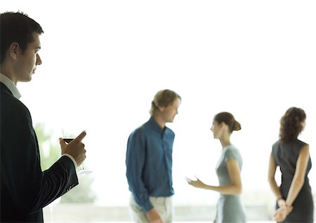 party couple on white background - Man watching man and woman talk during cocktail party Stock Photo - Premium Royalty-Free, Code: 695-05779002