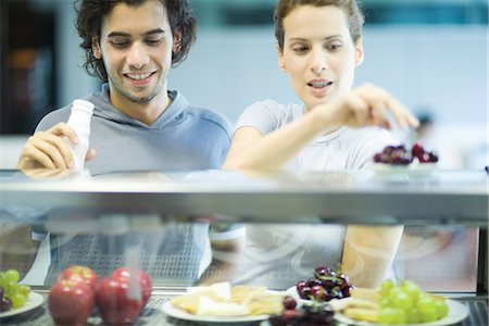 Young adults in exercise clothing, choosing snack in health club cafeteria Stock Photo - Premium Royalty-Free, Code: 695-05779095