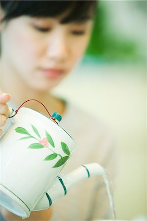 simsearch:656-04926611,k - Woman pouring tea from teapot Stock Photo - Premium Royalty-Free, Code: 695-05779091