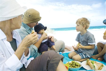 feeding grapes to men pictures - Grandparents and grandchildren having picnic on beach Stock Photo - Premium Royalty-Free, Code: 695-05779168