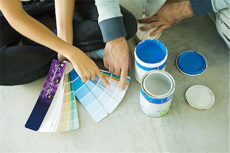 Couple sitting on floor, pointing to color swatches, cropped view Stock Photo - Premium Royalty-Free, Code: 695-05779189
