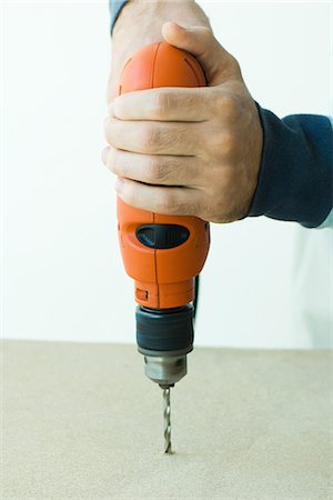 Man using drill, cropped view of hands Stock Photo - Premium Royalty-Free, Code: 695-05779206