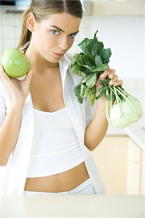 simsearch:695-03378760,k - Woman holding up fresh kohlrabi and apple, looking at camera Foto de stock - Sin royalties Premium, Código: 695-05779309