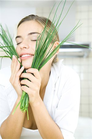 Young woman holding chives up to face, eyes closed Stock Photo - Premium Royalty-Free, Code: 695-05779314